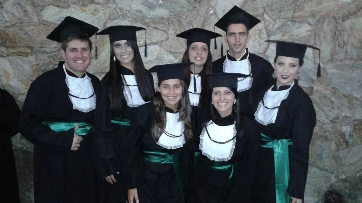 Turma de formandos com beca na colação de grau