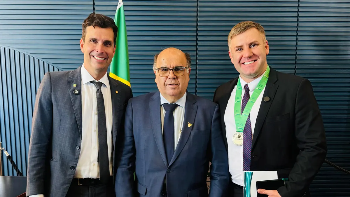 Maicon Gonçalves com a medalha ao lado de duas autoridades