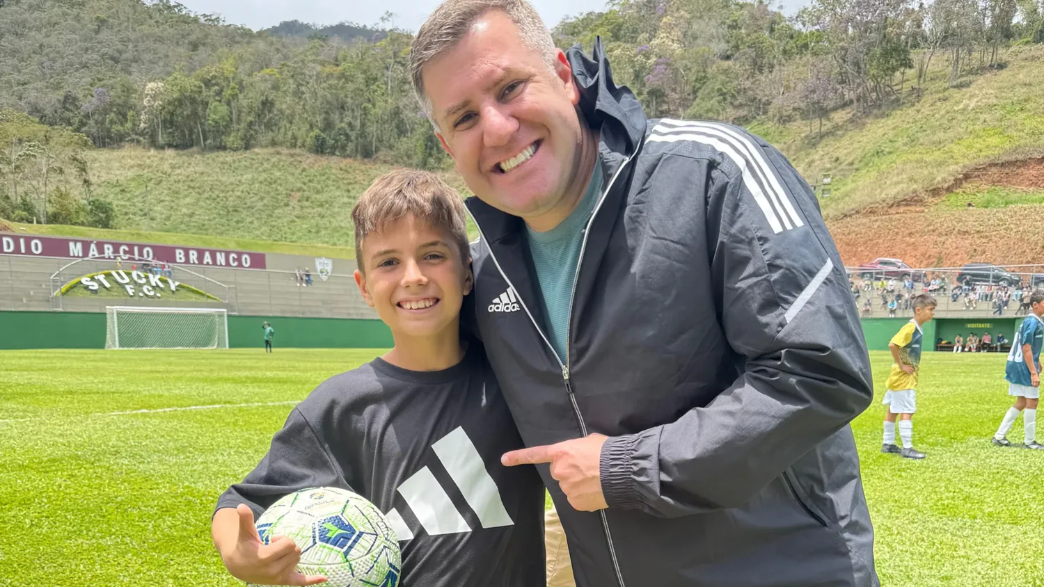 Maicon Gonçalves ao lado de um jovem atleta com uma bola no Estádio Márcio Branco